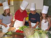 konzentrierte Kinder mit Freude beim Kochen